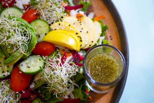 An olive oil salad dressing with fresh veggies